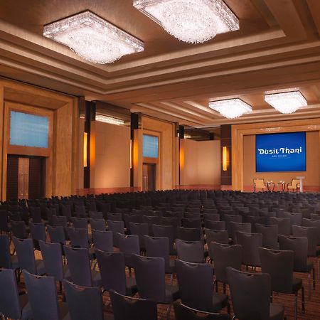 Dusit Thani Abu Dhabi Exterior photo The photo shows a well-lit auditorium or conference room set up for an event. The space features a large number of dark chairs arranged in rows facing a stage or presentation area. Above the stage, there is a screen displaying the text "Thank You!" i