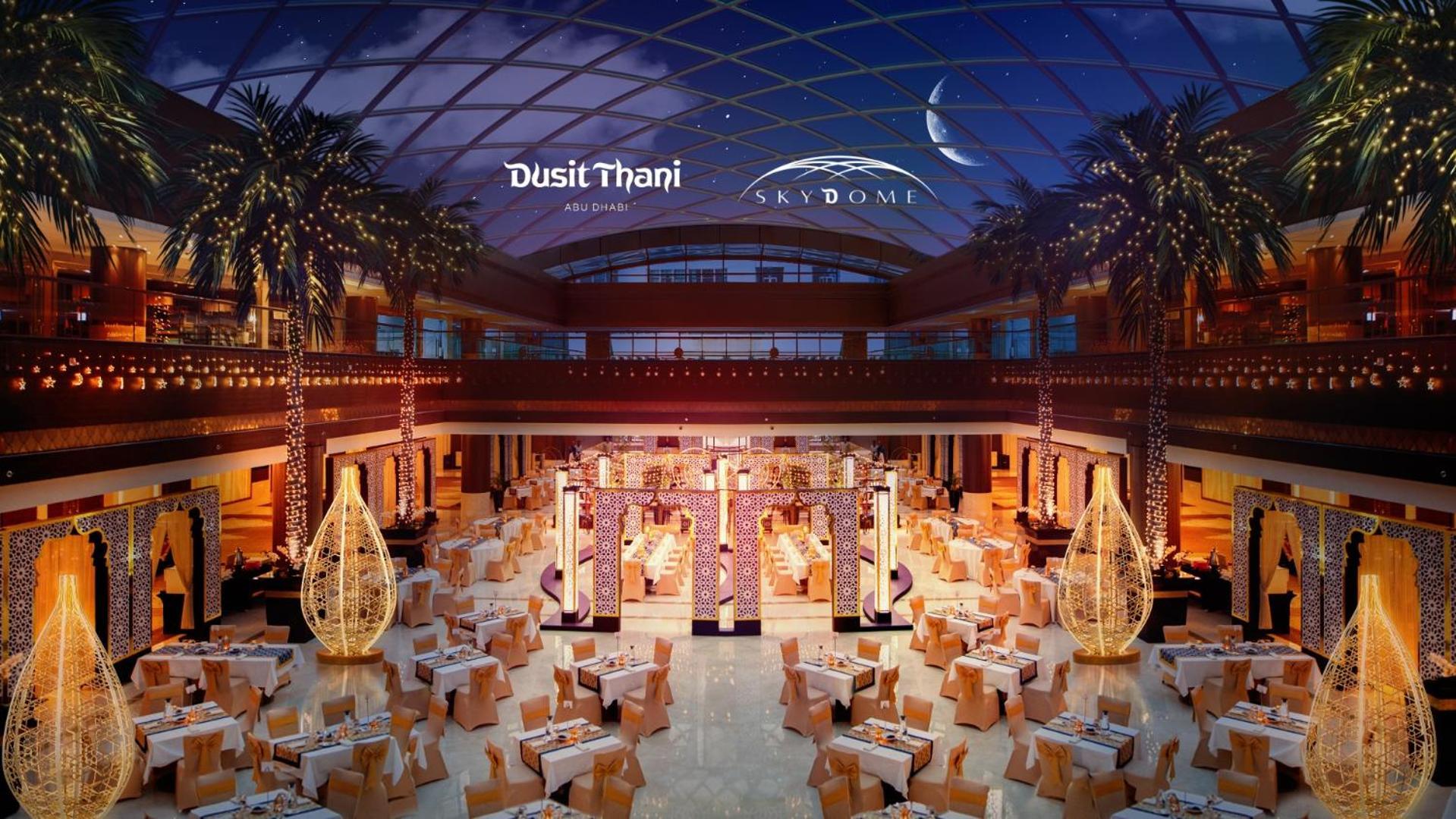 Dusit Thani Abu Dhabi Exterior photo The image depicts a luxurious dining space within a large venue, likely associated with Dusit Thani and Skydome. The interior features elegant decorations, including a spacious layout with numerous tables set for dining. Elegant lighting fixtures cre